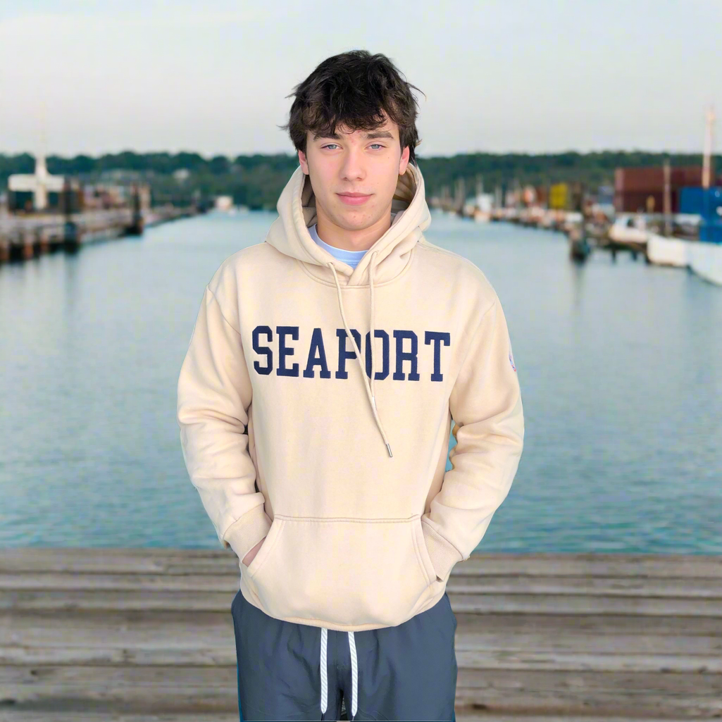 Man on harbor wearing cream color hoodie