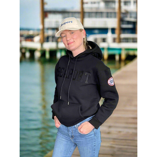 Woman on pier in thick black hoodie sweatshirt