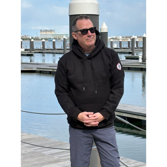 Man on boston harbor in back hoodie