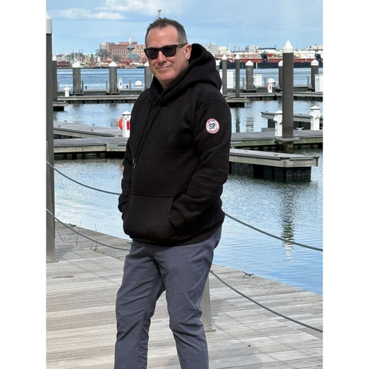 man wearing black heavyweight hoodie on harbor-walk in seaport