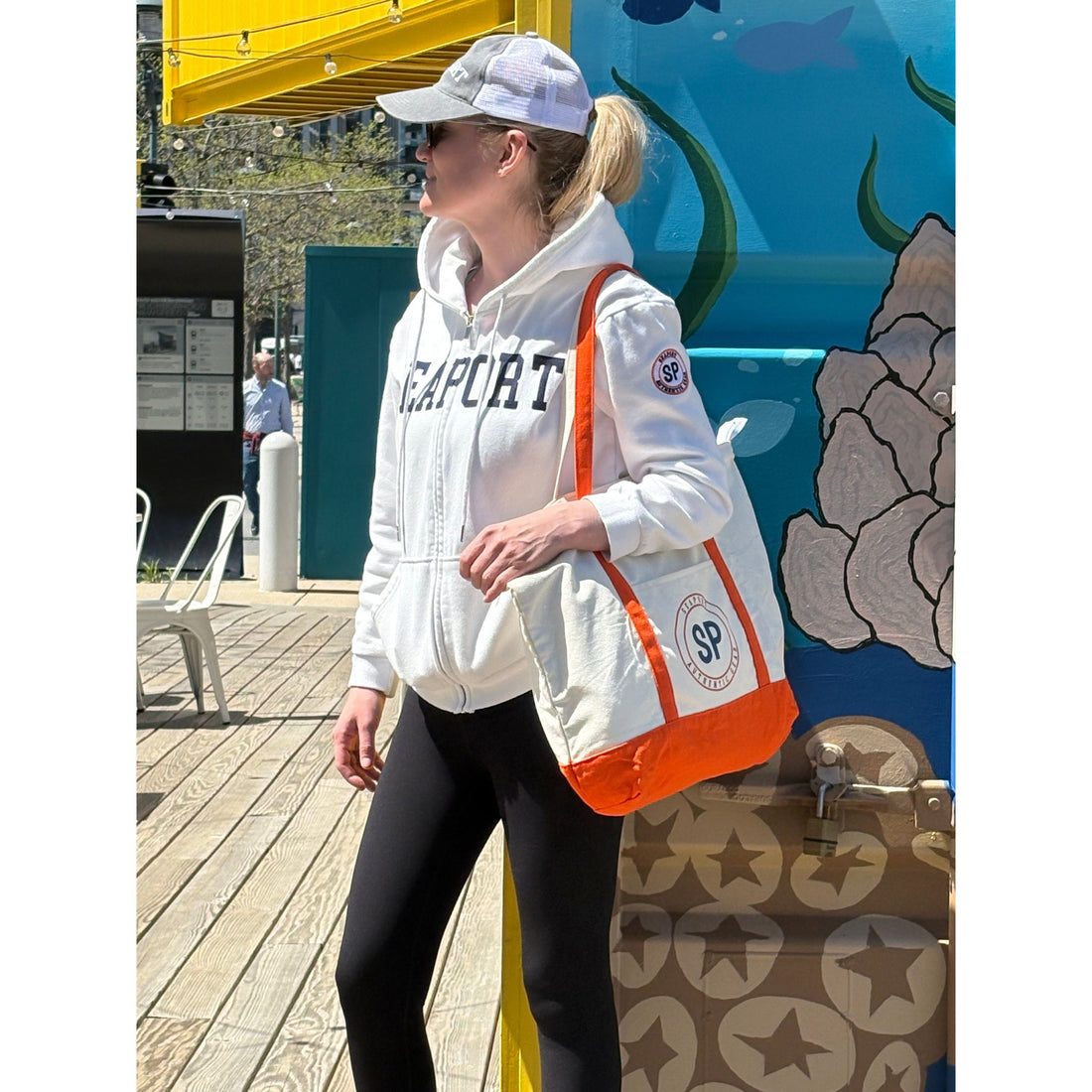woman wearing white hoodie with seaport text