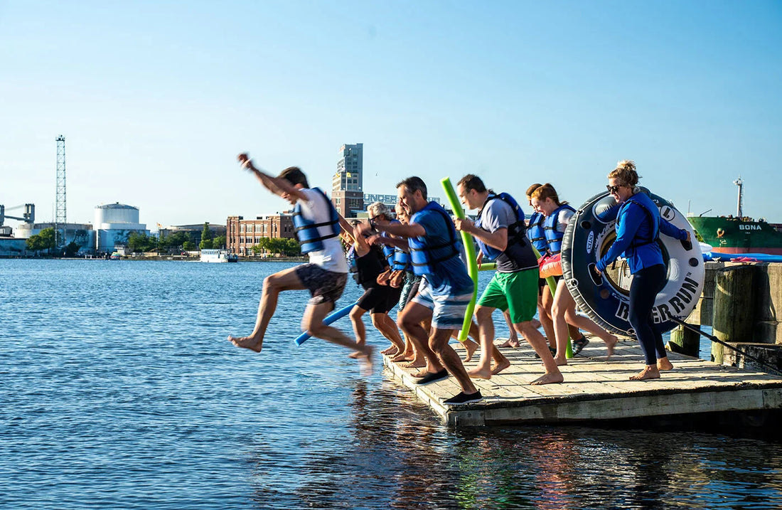 People jumping off pier into harbor