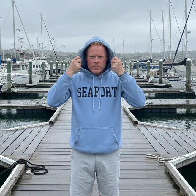Man on marina pulling a hood over his head