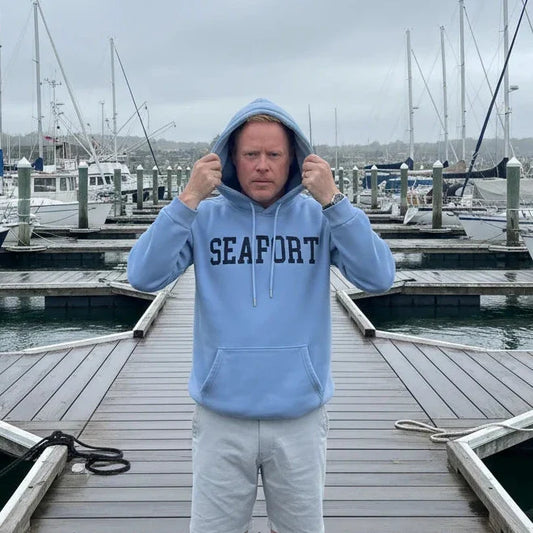 Man on marina pulling a hood over his head