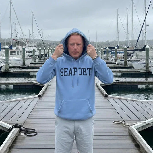 Man on marina pulling a hood over his head