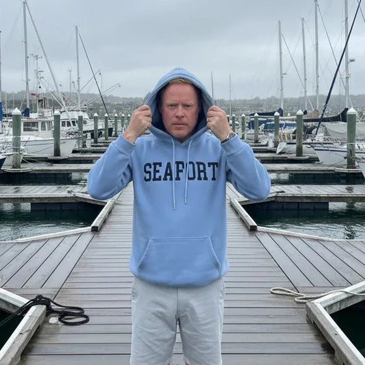 Man on marina pulling a hood over his head