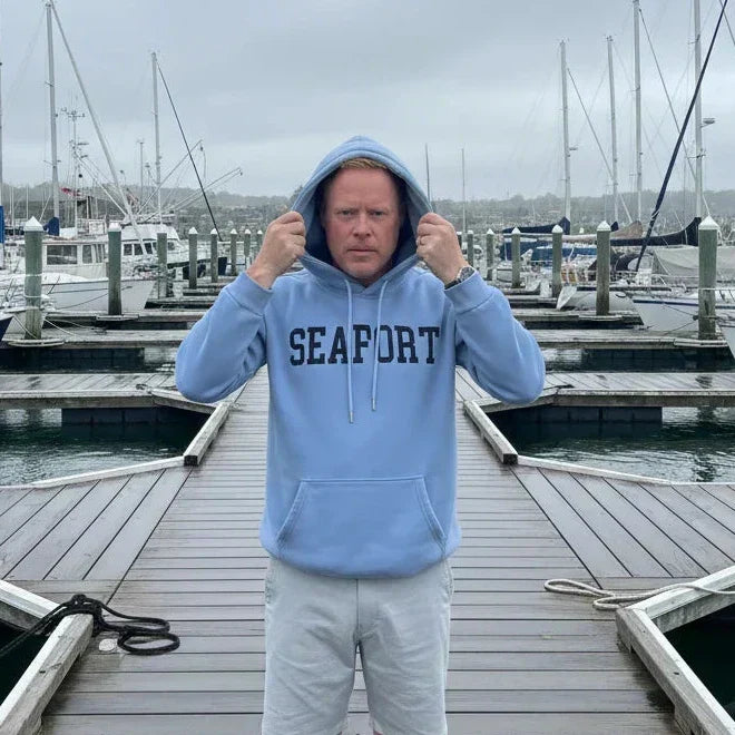 Man putting on a hood from his sweatshirt on a marina
