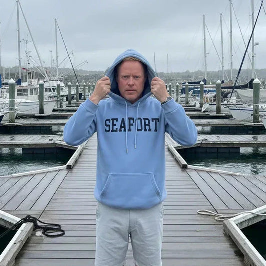 Man putting on a hood from his sweatshirt on a marina