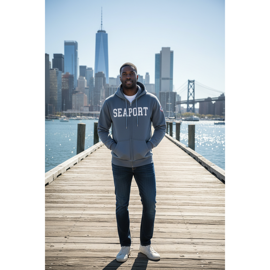 Man wearing Blue hoodie with 'Seaport' text and a patch on a city pier