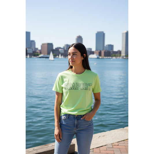 Woman on waterfront inLight green t-shirt with 'SEAPORT' text 